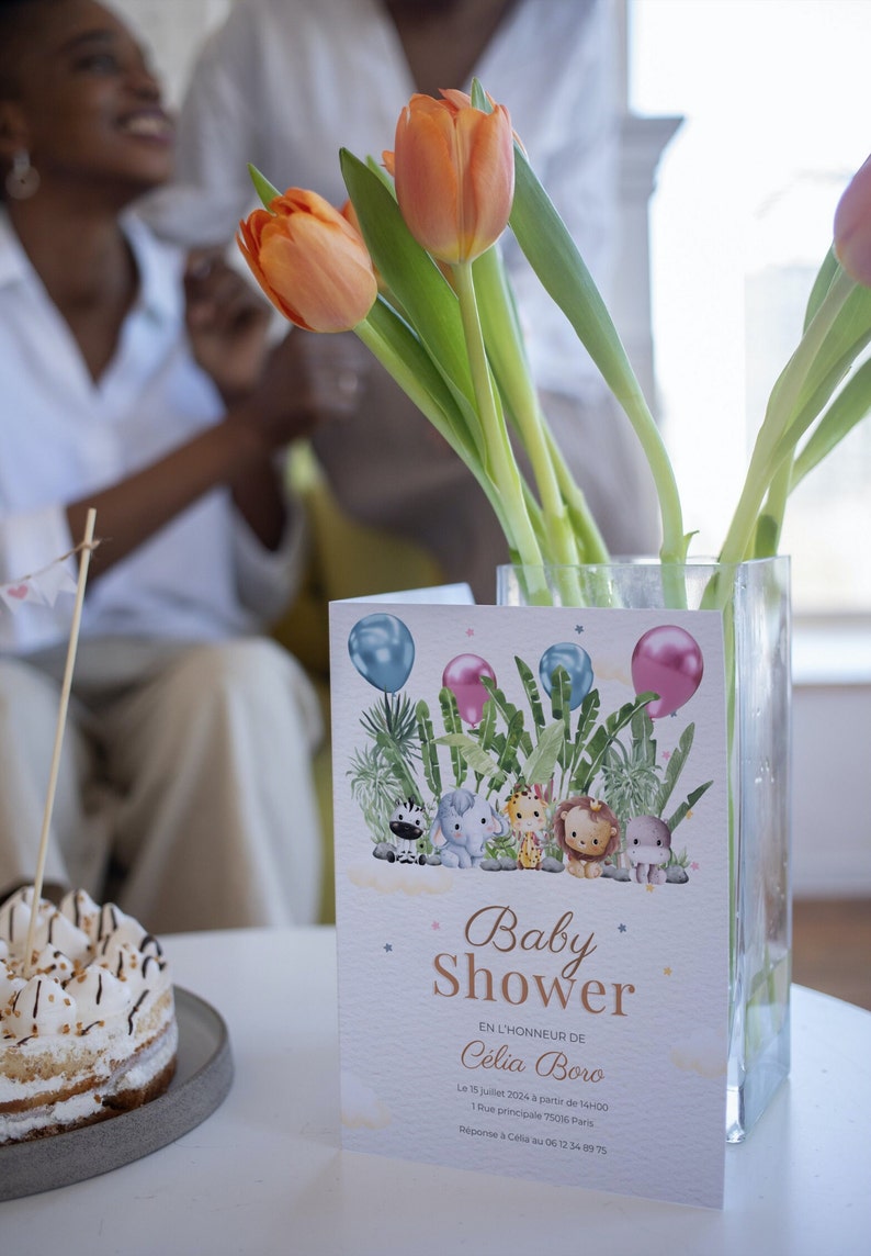 Pu&ograve; includere: Un invito a un baby shower a tema giungla. L'invito presenta una zebra, un elefante, un leone e un ippopotamo. Il testo sull'invito recita "Baby Shower" e "C&eacute;lia Boro". L'invito include anche la data, l'ora e la posizione del baby shower.