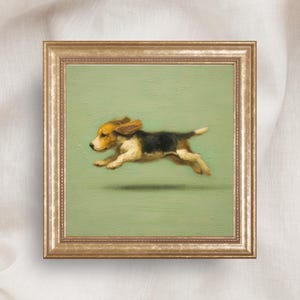 Pode incluir: Uma pintura quadrada emoldurada apresentando um pequeno cão beagle no ar, capturado em movimento de corrida. O cão tem pelagem castanha, preta e branca. O fundo é de uma cor verde sálvia sólida e suave. A obra está numa moldura dourada.