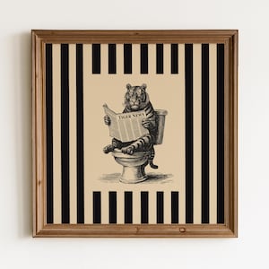 Könnte beinhalten: Ein quadratisches gerahmtes Wandbild mit einer schwarz-weißen Illustration eines Tigers, der auf einer Toilette sitzt und eine Zeitung mit der Aufschrift TIGER NEWS liest. Der Hintergrund besteht aus vertikalen schwarzen und beigen Streifen.