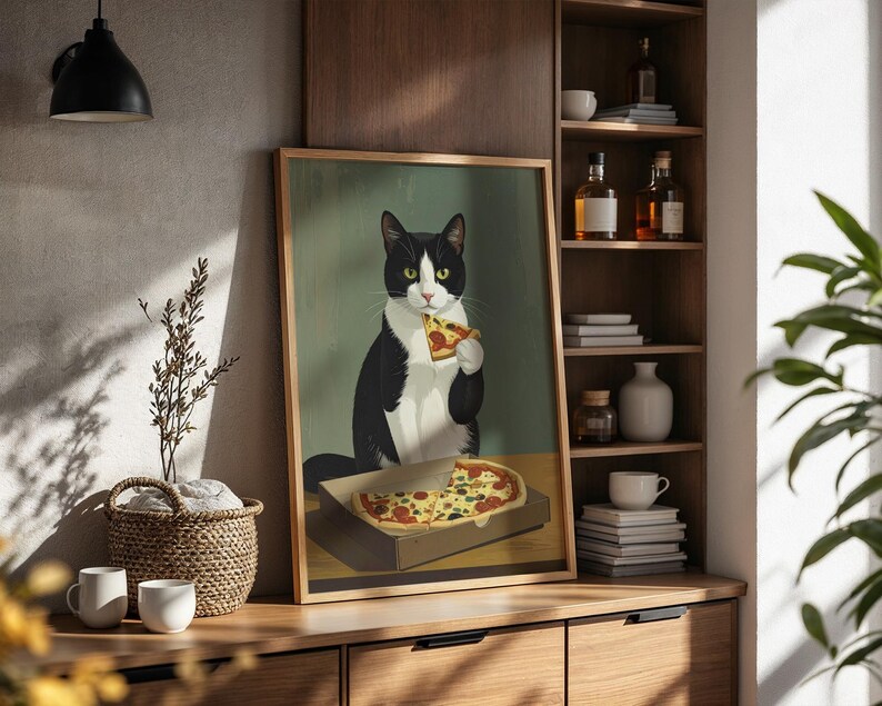 May include: A framed art print featuring a tuxedo cat enjoying a slice of pizza. The cat is black and white with green eyes, holding the pizza slice. The pizza is in a cardboard box, and the background is a muted green.