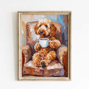 May include: A framed painting of a fluffy golden-brown dog sitting in a brown armchair while holding a white coffee mug. The artwork features visible brushstrokes in shades of tan, orange, and blue, presented in a light-colored wooden frame.