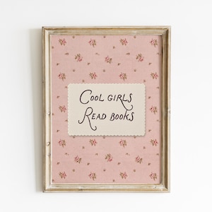 Könnte beinhalten: Ein rechteckiger Wandkunstdruck in einem verwitterten Holzrahmen mit einem altrosa Hintergrund und einem wiederkehrenden Muster aus kleinen roten Rosen und grünen Blättern. Mittig befindet sich eine cremefarbene Karte mit dem Text Cool girls Read books.