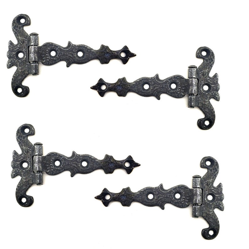 Puede incluir: Cuatro bisagras decorativas de estilo antiguo con un acabado texturizado en gris oscuro. Cada bisagra presenta un dise&ntilde;o ornamentado con un extremo curvado y enrollado y un extremo recto y puntiagudo, conectados por una bisagra central y m&uacute;ltiples orificios para tornillos.
