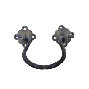 Könnte beinhalten: Antik-Stil Schubladengriff mit dunkler, gealterter Oberfläche. Der Griff hat ein gedrehtes Design, und die Montageplatten sind blütenförmig mit vier Schraubenlöchern. Ein klassisches Hardware-Teil.