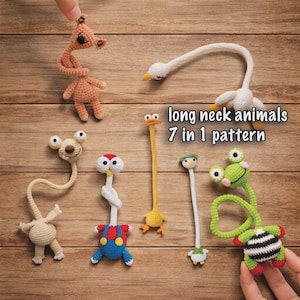 May include: A collection of seven crocheted animals with long necks, including a tan creature, a white swan, a beige character, a figure in blue overalls, a yellow bird, a small white bird, and a green frog with a black and white striped body.