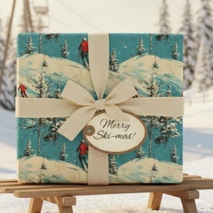 Könnte beinhalten: Ein Geschenk, verpackt mit einem Design einer Winterskiszene, gebunden mit einem cremefarbenen Band und einem Etikett mit der Aufschrift "Merry Ski-mas!". Das Geschenk liegt auf einem Holzschlitten in einer verschneiten Landschaft mit Kiefern und einem Skilift im Hintergrund.