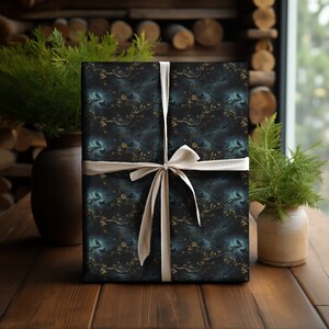May include: A dark blue gift wrap with a repeating pattern of black birds perched on gold branches. The gift is tied with a white ribbon.