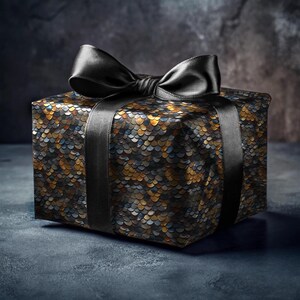 May include: A black gift box with a black satin ribbon bow. The box is wrapped in a patterned paper with a scale-like design in shades of gold, black, and blue.