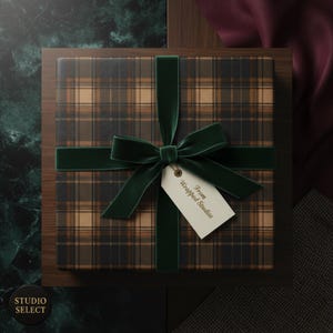 Puede incluir: Una caja de regalo cuadrada envuelta en papel a cuadros, con una cinta y lazo de terciopelo verde oscuro. Una etiqueta que dice "From Wrapped Studios" cuelga del lazo. La caja est&aacute; sobre una superficie de madera.
