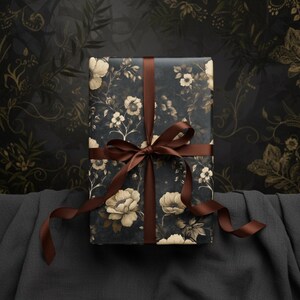 May include: A wrapped gift box featuring a dark blue floral pattern with cream-colored flowers and foliage. The box is tied with a brown satin ribbon, creating a bow. The background is a dark, patterned surface, suggesting a decorative or artistic theme.
