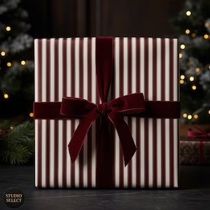 May include: A square gift, wrapped in paper with burgundy and cream stripes, and tied with a burgundy velvet ribbon and bow. The background features Christmas tree lights.