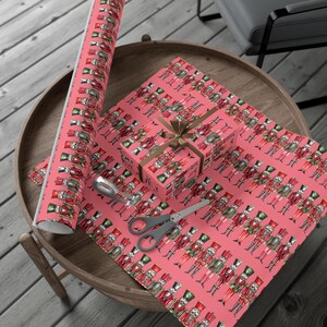 Festive nutcracker-themed wrapping paper with colorful soldiers on pink, perfect for Christmas gifts and holiday celebrations