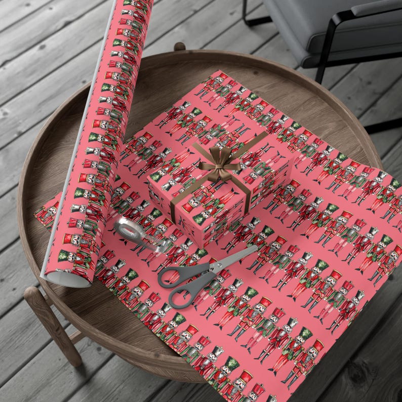 Festive nutcracker-themed wrapping paper with colorful soldiers on pink, perfect for Christmas gifts and holiday celebrations