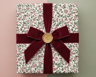 Carta da regalo con stampa floreale a piccoli motivi rosa e verdi, stile cottagecore.