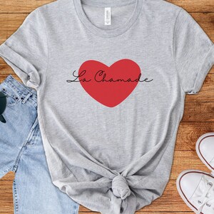 May include: A gray t-shirt with a red heart and the text "La Chamade" in black script.