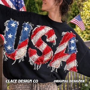 Puede incluir: Sudadera negra con la palabra "USA" aplicada en un diseño de patchwork con la bandera estadounidense. Las letras son rojas, blancas y azules con un borde deshilachado. El texto "CLACE DESIGN CO" y "ORIGINAL DESIGNER" están en la parte inferior.