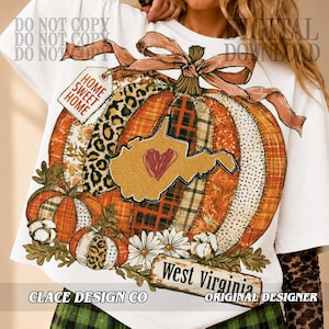 Könnte beinhalten: Ein weißes T-Shirt mit einer großen Kürbisgrafik, die aus verschiedenen Mustern wie Leopardenmuster, Karomuster und Blumen besteht. Eine Karte von West Virginia mit einem roten Herz ist auf dem Kürbis zentriert, der mit einer Schleife und einem Etikett mit der Aufschrift HOME SWEET HOME versehen ist. Ein Banner unten zeigt West Virginia.