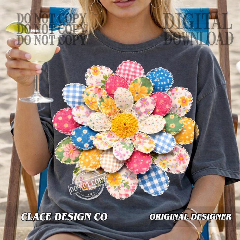 K&ouml;nnte beinhalten: Dunkelgraues T-Shirt mit einem gro&szlig;en, farbenfrohen Blumenmuster. Die Blume hat gemusterte Bl&uuml;tenbl&auml;tter in Rosa, Blau, Gelb und Gr&uuml;n. Das Shirt tr&auml;gt auch den Text "CLACE DESIGN CO" und "ORIGINAL DESIGNER".
