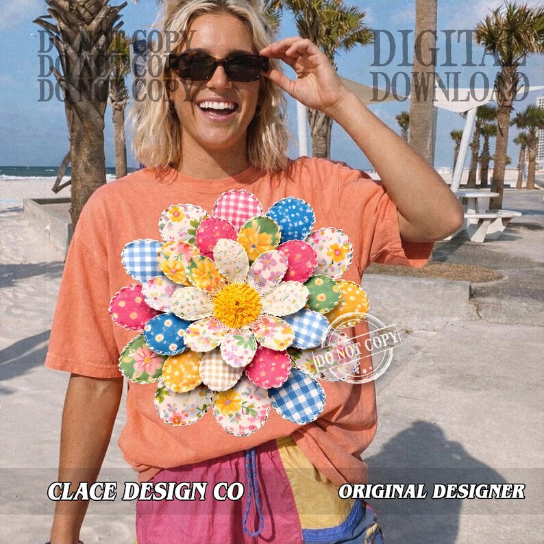 K&ouml;nnte beinhalten: Ein orangefarbenes T-Shirt mit einem gro&szlig;en, farbenfrohen Blumenmuster. Die Blume besteht aus verschiedenen gemusterten Stoffkreisen in Rosa, Blau, Gelb und Wei&szlig;. Der Text "CLACE DESIGN CO" und "ORIGINAL DESIGNER" sind sichtbar.
