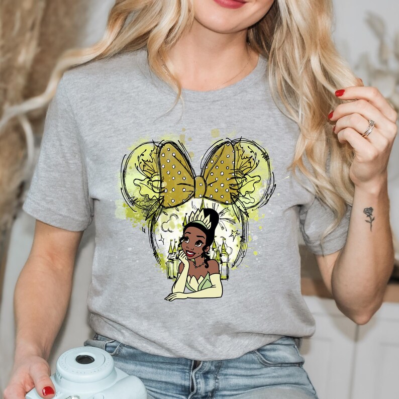 a woman holding a teapot and wearing a t - shirt with a picture of