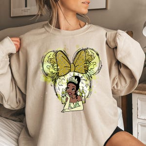 a woman wearing a sweatshirt with a picture of minnie mouse on it