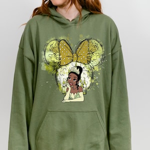 a woman wearing a green hoodie with a picture of a woman's face