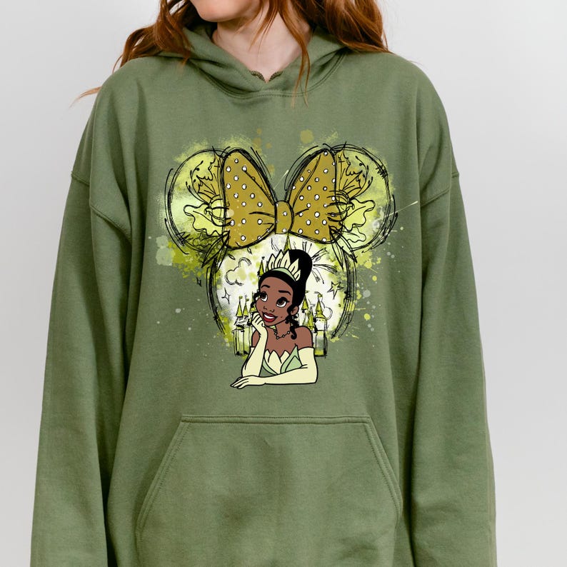 a woman wearing a green hoodie with a picture of a woman's face