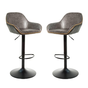 May include: Two grey faux leather bar stools with black metal frames and footrests. The stools have a swivel base and adjustable height.