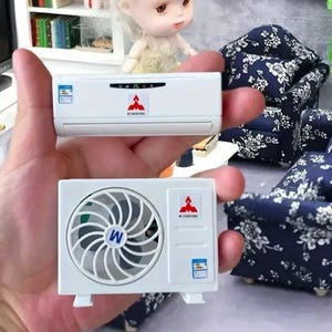 Op de afbeelding: Miniatuur witte airconditioning units. Eén unit heeft een ventilator, de andere een display. Beide units hebben een rood logo en de tekst "WIDEXIANG". Dit zijn poppenhuisaccessoires.