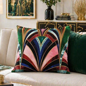 Peut inclure: Un coussin carré décoratif arborant un motif géométrique symétrique en éventail, décliné dans des tons vifs de vert émeraude, bleu profond, magenta et noir. Le design présente des lignes dorées complexes soulignant les formes rayonnantes.