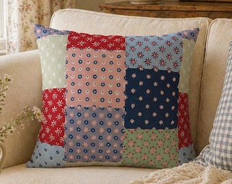 Może przedstawiać: Poduszka patchwork z różnymi wzorami kwiatowymi w kolorach czerwonym, różowym, niebieskim i zielonym leży na kremowej sofie. Widoczna jest również druga poduszka z niebiesko-białym wzorem w kratę. Scena przywołuje przytulną estetykę cottagecore.