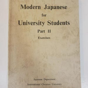 May include: A beige softcover textbook titled Modern Japanese for University Students Part II Exercises, published by the Japanese Department of International Christian University. The cover features dark brown text on a textured, light-colored background.