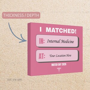 K&ouml;nnte beinhalten: Ein pinkfarbener Leinwanddruck mit dem Text "I MATCHED!" und den S&auml;tzen "IN: Internal Medicine" und "AT: Your Location Here". Auf der Unterseite des Drucks steht "MATCH DAY 2026" mit einem medizinischen Symbol.