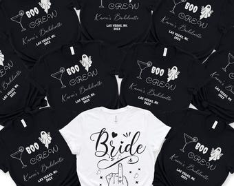 May include: A collection of black and white t-shirts. Most shirts feature a cocktail glass, ghost, and text that reads "800 Crew Karen's Bachelorette Las Vegas, NV. 202X." One white shirt says "Bride" with a hand gesture.