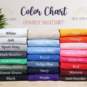 May include: A color chart for a crewneck sweatshirt displays various colors, including white, ash, sport gray, and black. Other colors include Irish green, navy, and purple. The text "Color Chart" is at the top.