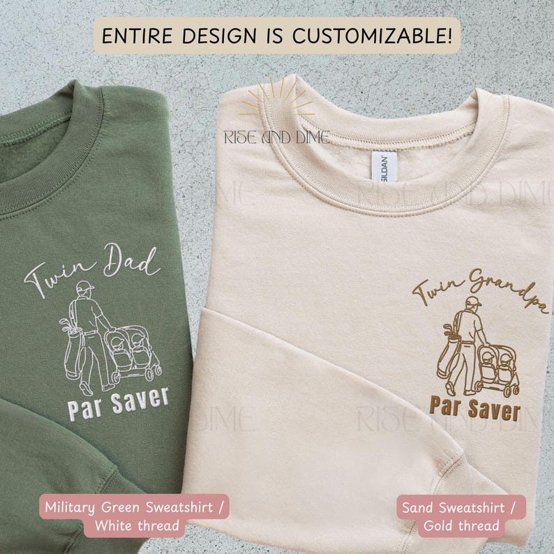 May include: Two sweatshirts, one military green and one sand-colored, feature golf-themed designs. The green sweatshirt has "Twin Dad" and "Par Saver" text with a white thread design. The sand sweatshirt has "Twin Grandpa" and "Par Saver" with gold thread.