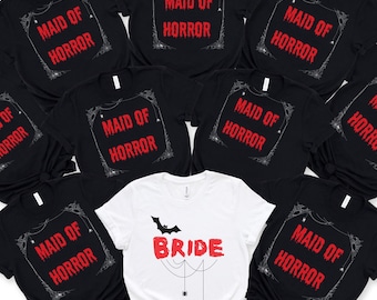 May include: A collection of black t-shirts with the text "MAID OF HORROR" in red, framed by a spiderweb design. A white t-shirt with the word "BRIDE" in red, a bat, and spider graphics is also included.
