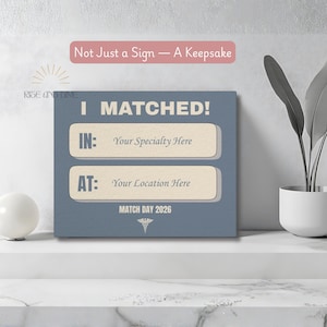 K&ouml;nnte beinhalten: Ein quadratisches, blaues Schild mit dem Text "I MATCHED!" und Feldern f&uuml;r Fachgebiet und Standort. Das Schild enth&auml;lt auch den Text "MATCH DAY 2026" und "Not Just a Sign - A Keepsake".