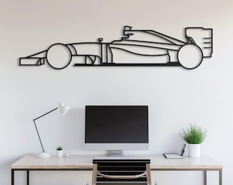 May include: Black metal wall art depicting a Formula One race car. The car is in profile view and has a sleek, modern design. The art piece is mounted on a white wall and is displayed above a desk with a computer, lamp, and chair.