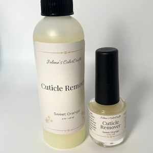 May include: Two bottles of cuticle remover. The larger bottle has a black cap and a label that reads "Jolene's ColorCrafts Cuticle Remover Sweet Orange 118 ml." The smaller bottle has a black cap and a label that reads "Jolene's ColorCrafts Cuticle Remover Sweet Orange 15 ml."