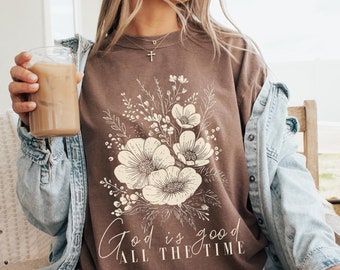 May include: A brown t-shirt with a floral design and the text "God is good all the time".