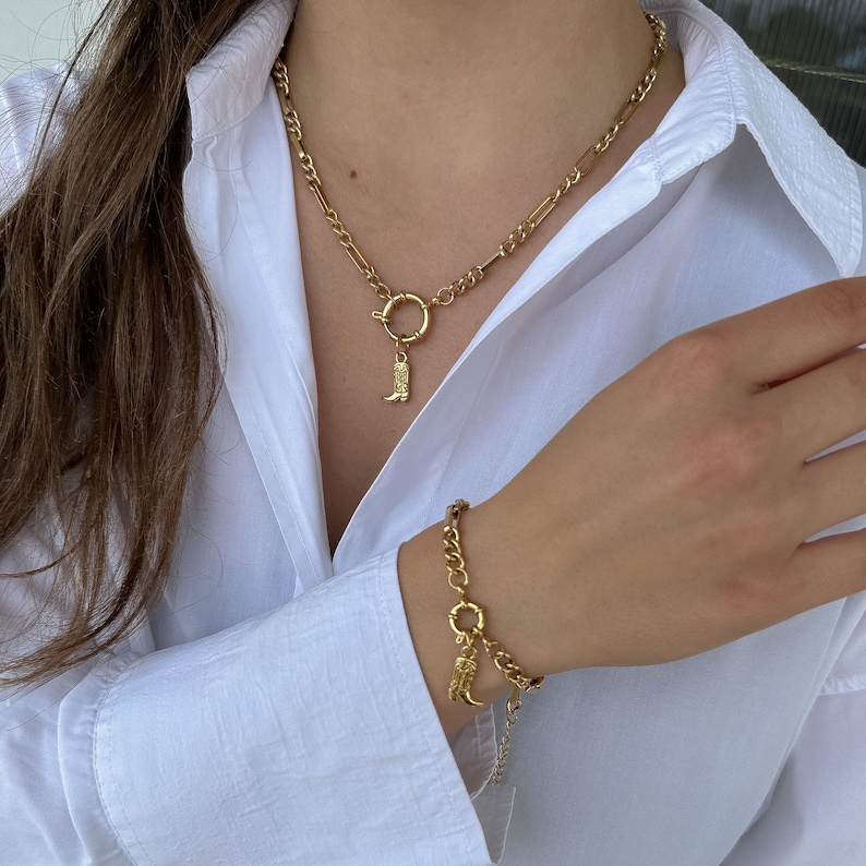 May include: A gold chain necklace with a boot charm and a gold chain bracelet with a boot charm.