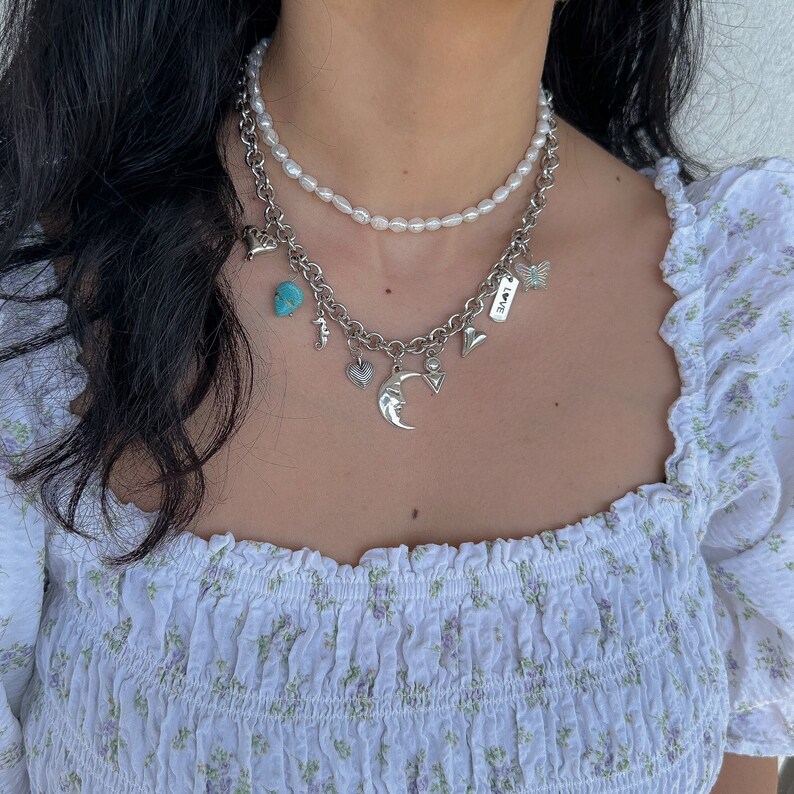 In this listing you can find 2 different necklaces. One freshwater pearl choker necklace and a unique silver charm necklace made with stainless steel chain and silver plated charm made from zamak or stainless steel.