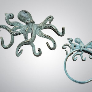May include: A cast metal wall hook set featuring a large octopus with multiple curved tentacles for hanging items and a smaller octopus integrated into a circular towel ring, both finished in a weathered, verdigris-toned teal and bronze patina.