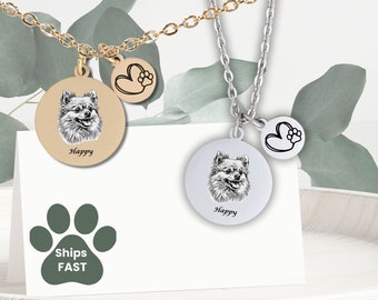 May include: Two silver necklaces with a round pendant featuring a black and white dog portrait and a small heart charm with a paw print. The pendant is engraved with the word "Happy".