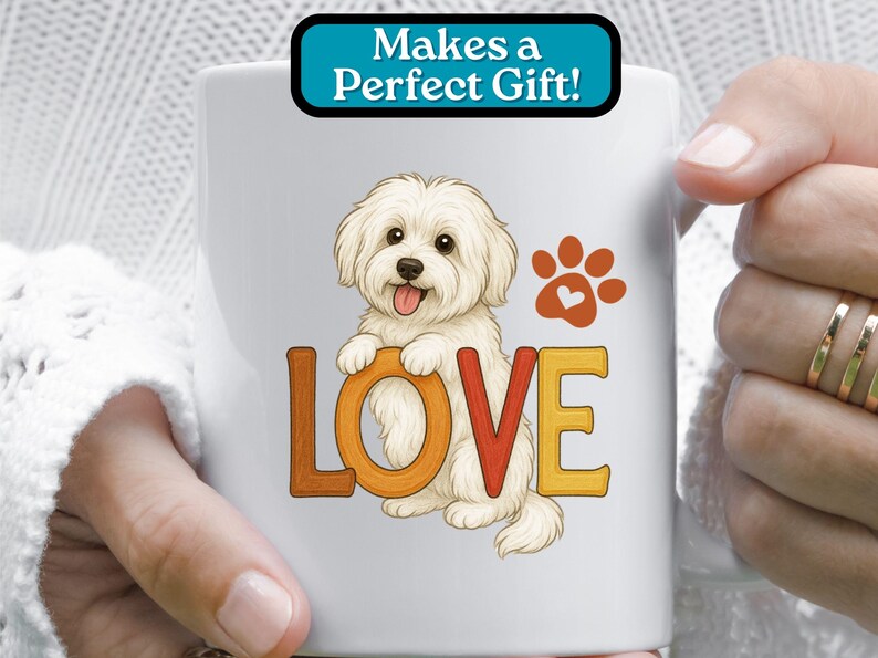 Puede incluir: Taza de caf&eacute; de cer&aacute;mica blanca con una imagen de dibujos animados de un perro blanco con la palabra "LOVE" en letras de colores. El perro sostiene una huella de pata con un coraz&oacute;n en el centro. El texto "Makes a Perfect Gift!" est&aacute; en un cuadro azul en la parte superior de la taza.