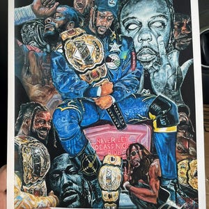 May include: A colorful print featuring a central figure in a blue outfit, holding a gold championship belt, surrounded by other figures and championship belts. The print includes the text "NEVER LET NO ASS NIGG RIDE".