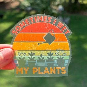 May include: A sticker with a retro sunset design and the text "Sometimes I Wet My Plants". The sticker features a watering can pouring water on a row of plants.