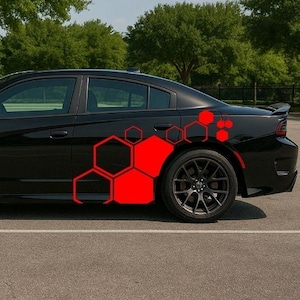 May include: Black saloon car with red hexagonal decals. The vehicle has black alloy wheels and is parked on a paved surface. The background features green trees and a blue sky.
