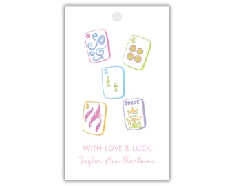May include: A white gift tag with a colorful illustration of five playing cards. The cards are a number 2, a number 3, a number 4, a joker, and a card with a swirl design. The text "WITH LOVE & LUCK" and "Taylor Ann Hartman" is printed on the tag.